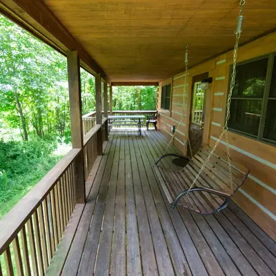 a porch of a house with a swing at Dogwood - by The Chalets in Logan