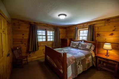 a bedroom with a bed in a log cabin at Dogwood - by The Chalets in Logan
