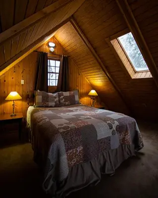 a bedroom with a large bed in a attic at Elk - by The Chalets in South Bloomingville