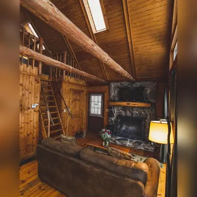 a living room with a couch and a fireplace at Elk - by The Chalets in South Bloomingville
