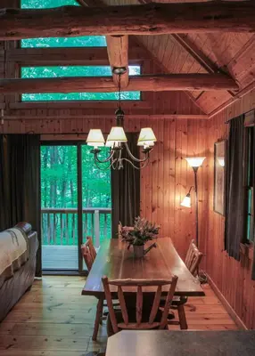a dining room with a wooden table and chairs at Elk - by The Chalets in South Bloomingville
