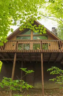 a tree house with a deck on top of it at Elk - by The Chalets in South Bloomingville