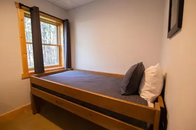 a bedroom with a wooden bed with a window at Evergreen - by The Chalets in Laurelville