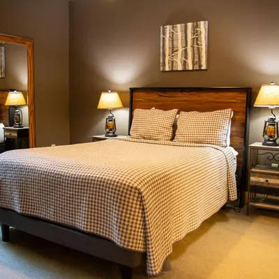 a bedroom with a bed with a checkered blanket and two lamps at Evergreen - by The Chalets in Laurelville
