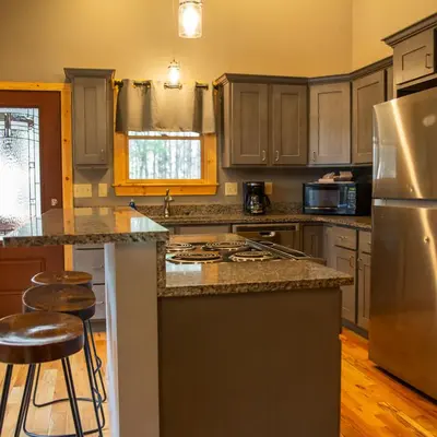 a kitchen with a stainless steel refrigerator and a counter at Evergreen - by The Chalets in Laurelville