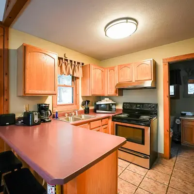 a kitchen with wooden cabinets and a red counter top at Falls - by The Chalets in Logan