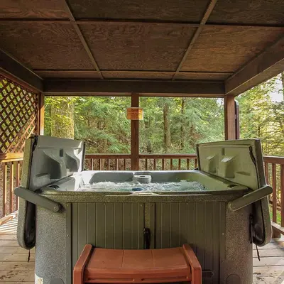 a hot tub on the deck of a cabin at Falls - by The Chalets in Logan