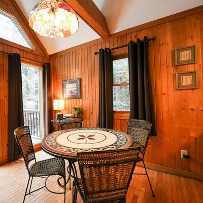a dining room with a table with chairs and a clock at Falls - by The Chalets in Logan