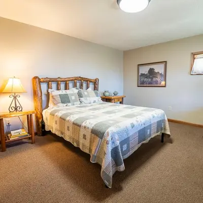 a bedroom with a large bed with a wooden frame at Fallswood Lodge - by The Chalets in Logan