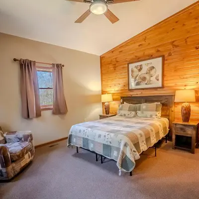 a bedroom with a bed and a ceiling fan at Fallswood Lodge - by The Chalets in Logan
