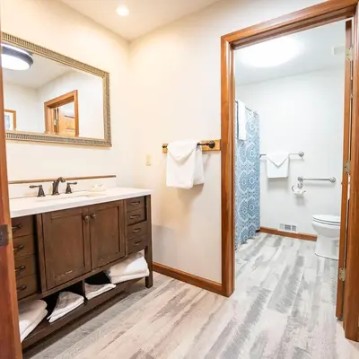 a bathroom with a sink and a toilet and a mirror at Fallswood Lodge - by The Chalets in Logan