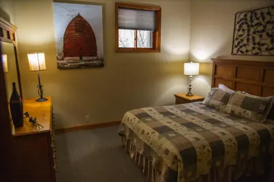 a bedroom with a bed and two lamps and a window at Fireside Lodge - by The Chalets in Logan