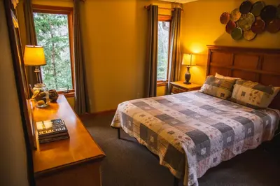 a bedroom with a bed and a table with a night stand at Fireside Lodge - by The Chalets in Logan