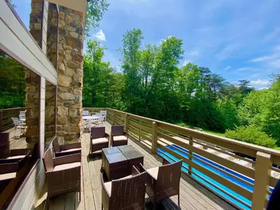 a balcony with chairs and a table and trees at Fireside Lodge - by The Chalets in Logan