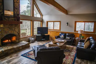 a living room with a fireplace and a tv at Fireside Lodge - by The Chalets in Logan