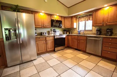 a kitchen with wooden cabinets and stainless steel appliances at Grande Butte Lodge - by The Chalets in Laurelville