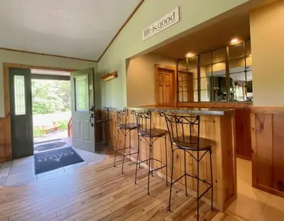 a kitchen with a bar with stools in it at Grande Butte Lodge - by The Chalets in Laurelville