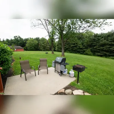two chairs and a barbecue grill in a yard at Grande Butte Lodge - by The Chalets in Laurelville