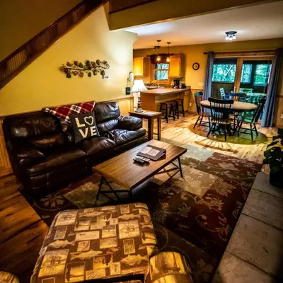a living room with a leather couch and a table at Hawks Peak - by The Chalets in Logan