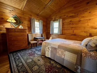 a bedroom with a bed in a wooden cabin at Hemlock - by The Chalets in Logan
