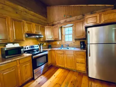 a kitchen with wooden cabinets and a stainless steel refrigerator at Hemlock - by The Chalets in Logan