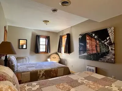 a bedroom with two beds and a painting on the wall at Hemlock - by The Chalets in Logan