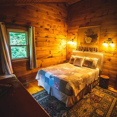 a bedroom with a bed in a log cabin at Hemlock - by The Chalets in Logan