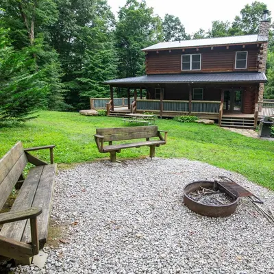 a group of benches in front of a log cabin at Hidden Heights - by The Chalets in South Bloomingville