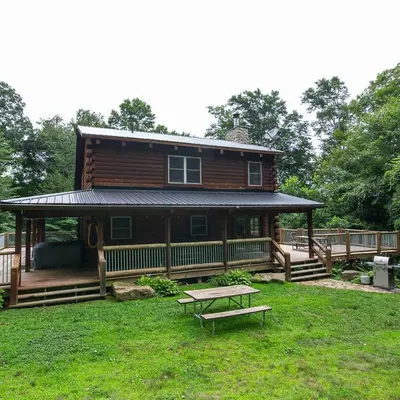a large wooden house with a picnic table in the yard at Hidden Heights - by The Chalets in South Bloomingville