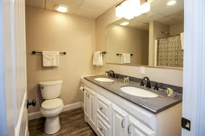 a bathroom with two sinks and a toilet and a mirror at Lakeview - by The Chalets in Logan
