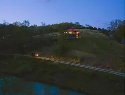a house on a hill with a train on the tracks at Lakeview - by The Chalets in Logan