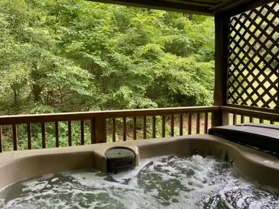 a bath tub on a porch with water in it at Laurelwood - by The Chalets in Logan