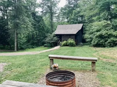 a dog sitting on the grass next to a bench at Laurelwood - by The Chalets in Logan