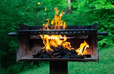 a grill with fire in it in a yard at Laurelwood - by The Chalets in Logan
