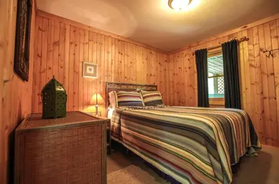 a bedroom with wooden walls and a bed and a window at Laurelwood - by The Chalets in Logan