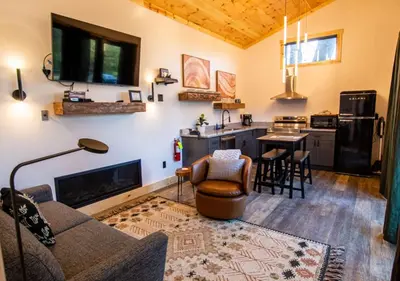 a living room with a couch and a kitchen at Legends Lane A - by The Chalets in Logan