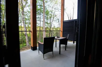 a patio with a table and chairs on a balcony at Legends Lane B - by The Chalets in Logan