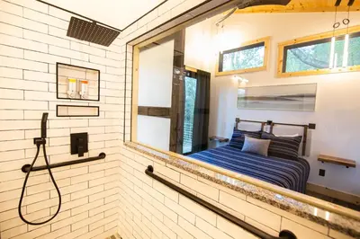 a bathroom with a shower and a bed in it at Legends Lane B - by The Chalets in Logan