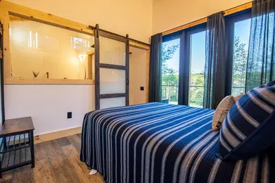 a bedroom with a bed with a ladder and windows at Legends Lane C - by The Chalets in Logan