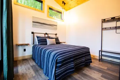a bedroom with a bed with a blue and white striped blanket at Legends Lane D - by The Chalets in Logan
