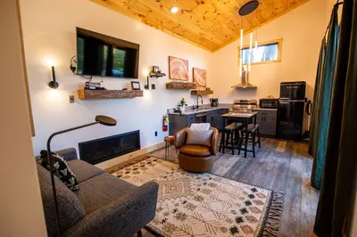 a living room with a couch and a table and a kitchen at Legends Lane D - by The Chalets in Logan