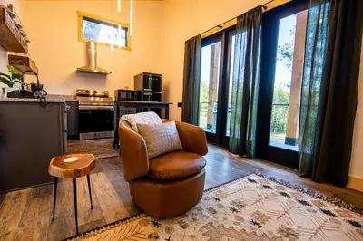 a living room with a chair and a television at Legends Lane E - by The Chalets in Logan