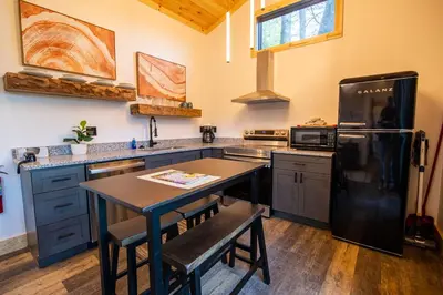 a kitchen with a black refrigerator and a table at Legends Lane E - by The Chalets in Logan