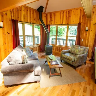 a living room with a couch and a chair and a stove at Lilypad - by The Chalets in Logan