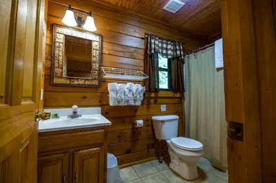 a wooden bathroom with a toilet and a sink at Oakridge - by The Chalets in South Bloomingville
