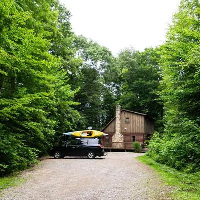 a car parked in front of a barn with a surfboard on top at Oakridge - by The Chalets in South Bloomingville