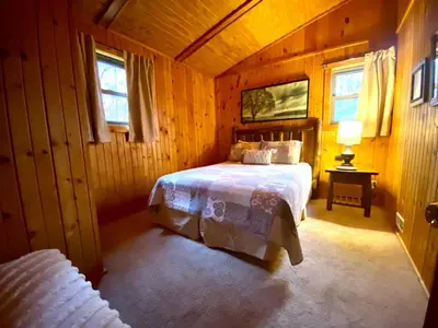 a bedroom with a bed in a wooden room at Oakridge - by The Chalets in South Bloomingville