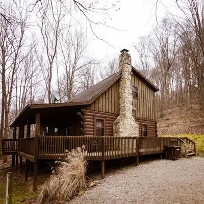 a log cabin with a chimney and a fence at Oakridge - by The Chalets in South Bloomingville