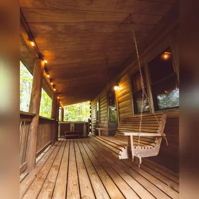 a porch of a log cabin with a swing at Oakridge - by The Chalets in South Bloomingville