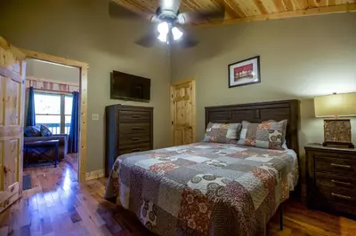 a bedroom with a bed and a dresser and a window at Overlook - by The Chalets in Logan